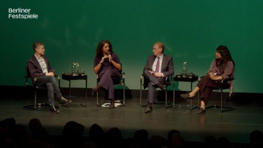 People sit on a stage and look at each other.