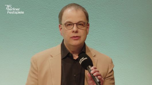 Sascha Westphal spricht in ein Mikrofon und gestikuliert mit seiner linken Hand