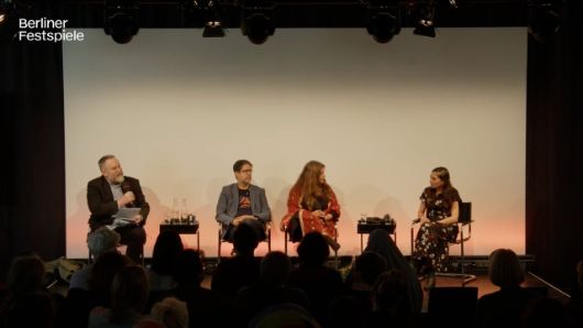 People sit on a stage and look at each other.