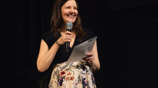 Nora Hertein-Hull, die Leiterin des Theatertreffens, steht an einem Rednerpult.