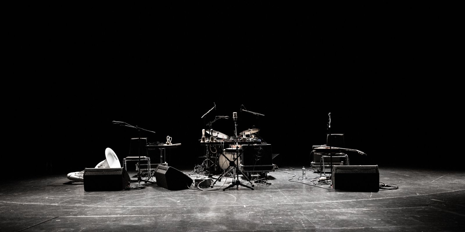 Blasinstrumente, Schlagzeug und ein Bass auf einer ansonsten leeren Bühne