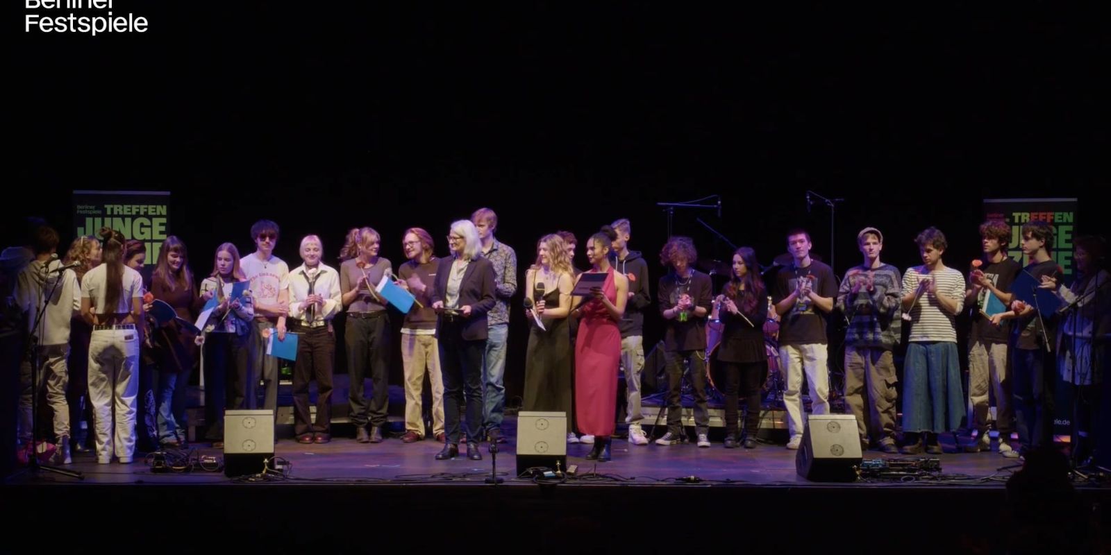 Viele Menschen stehen auf einer Bühne.