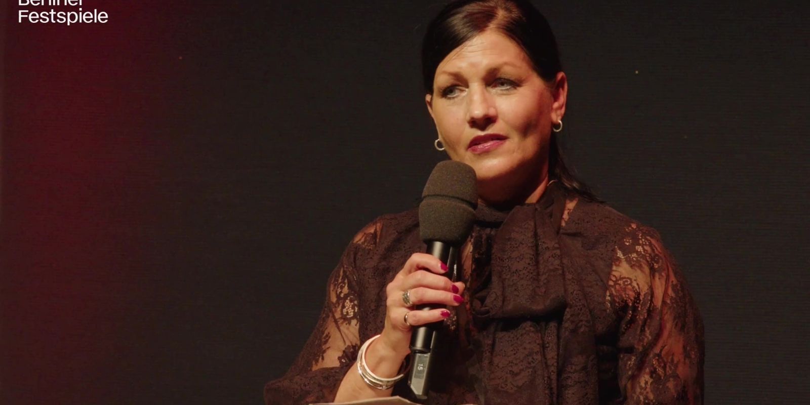Close-up of a woman holding a microphone.