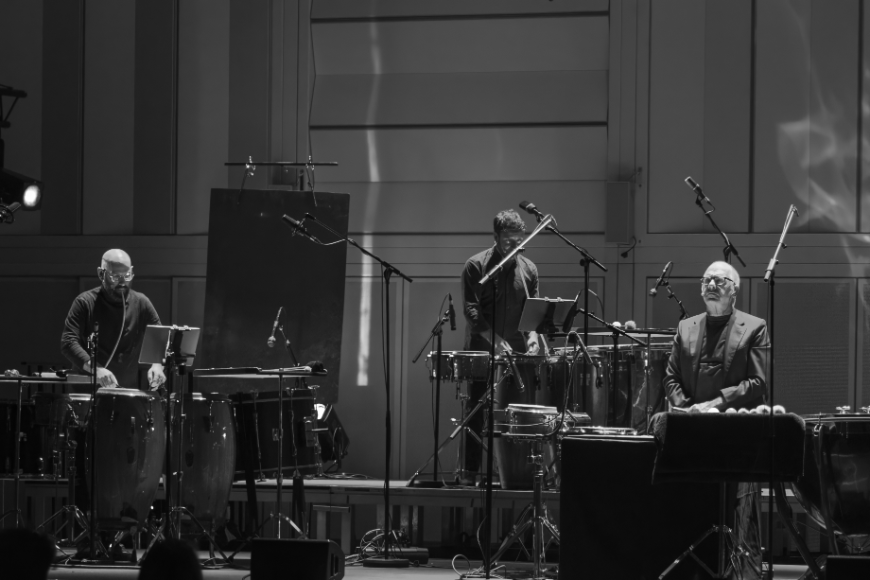 Drei Perkussionist*innen an ihren Instrumenten auf der Bühne