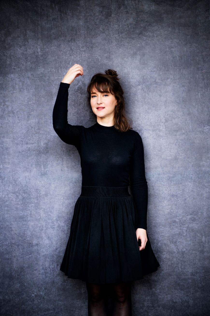 The composer Lisa Streich with a gesture as if she were holding a double bass.