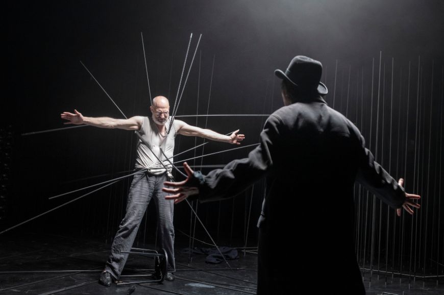 Ein Mann wird von langen dunklen Stäben durchbohrt.