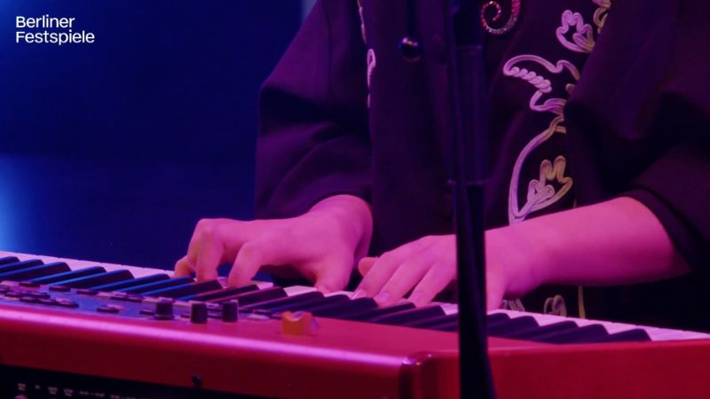 Two hands play the piano.